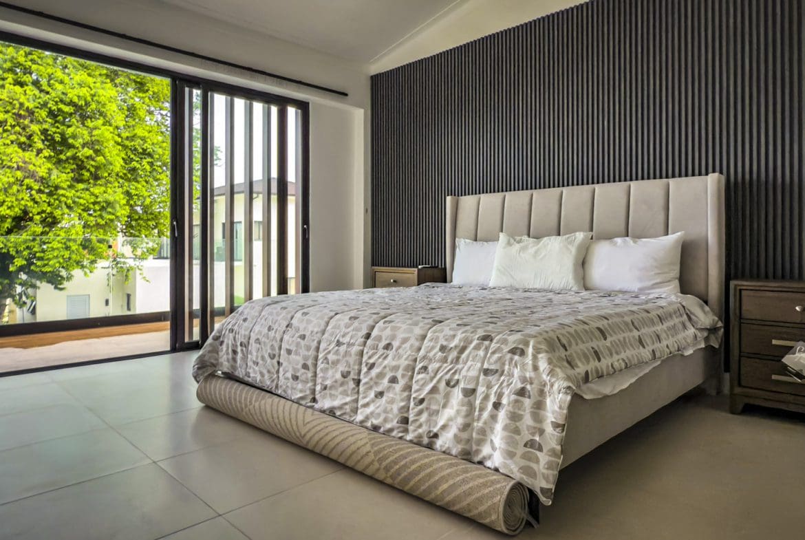 buyDRproperty Luxury bedroom in Sosua Ocean Village villa with sliding doors to a balcony and garden view. Sosua Real Estate