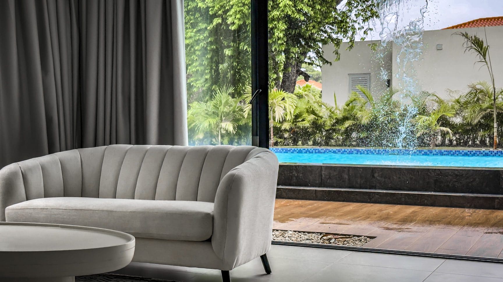 buyDRproperty Luxury villa interior with a modern sofa and pool view, Sosua Ocean Village. Sosua Real Estate