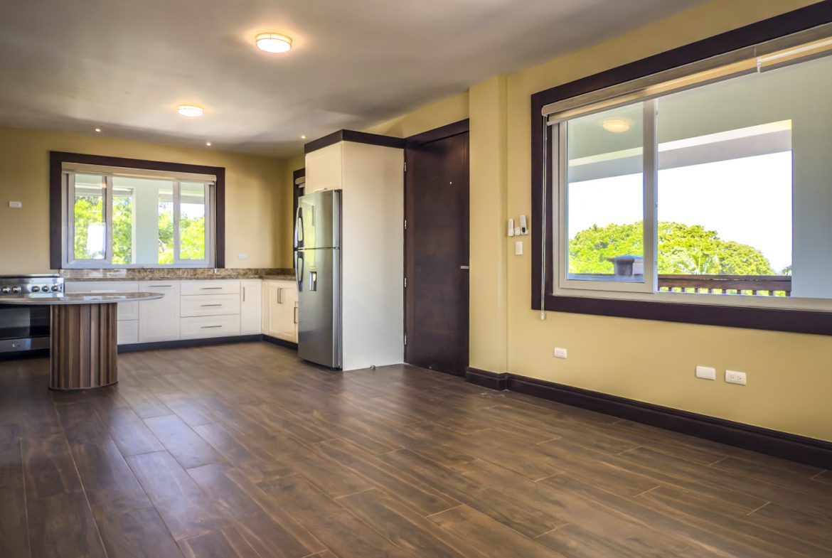 buyDRproperty Bright kitchen and dining area in La Mulata villa for sale, featuring wood floors and large windows. Sosua Real Estate