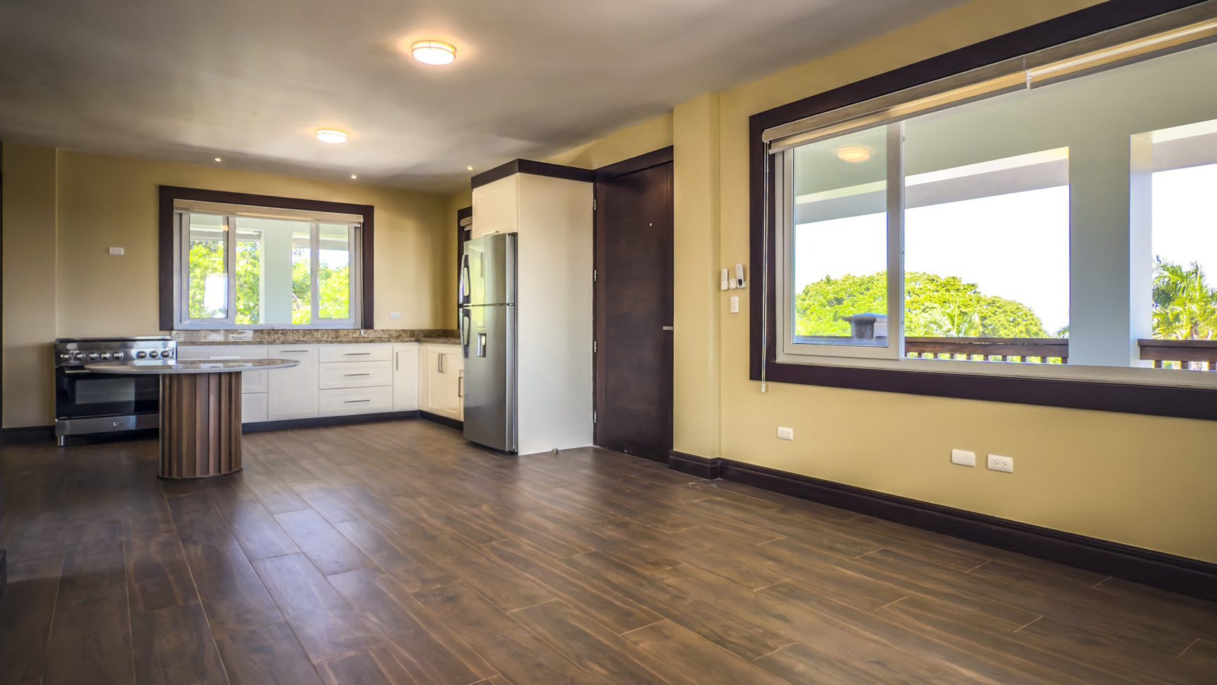 buyDRproperty Bright kitchen and dining area in La Mulata villa for sale, featuring wood floors and large windows. Sosua Real Estate