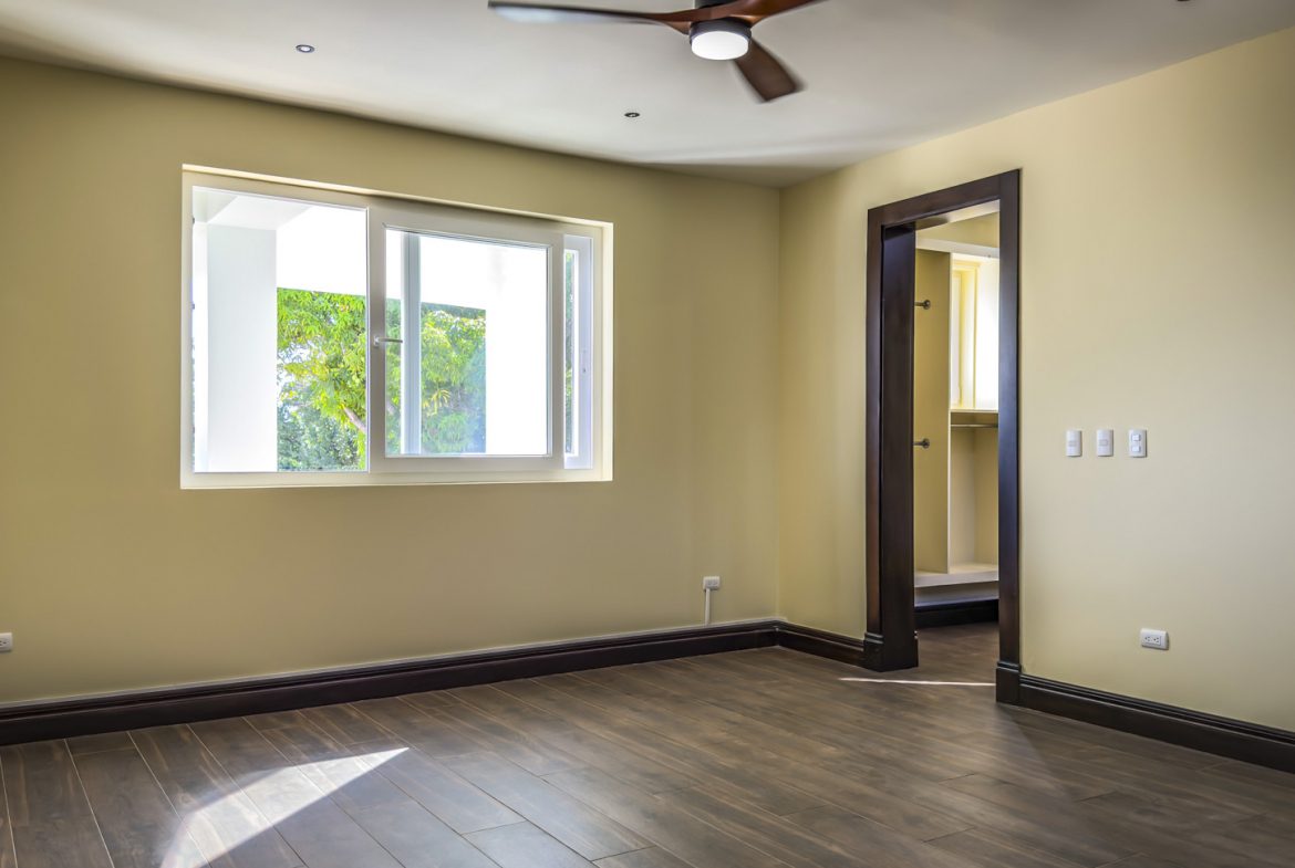 buyDRproperty Bedroom in La Mulata villa for sale with hardwood floors, window, and door to another room. Sosua Real Estate