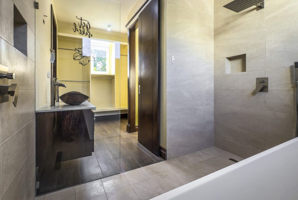 buyDRproperty Modern bathroom with walk-in shower, vanity, and closet in La Mulata villa. Sosua Real Estate