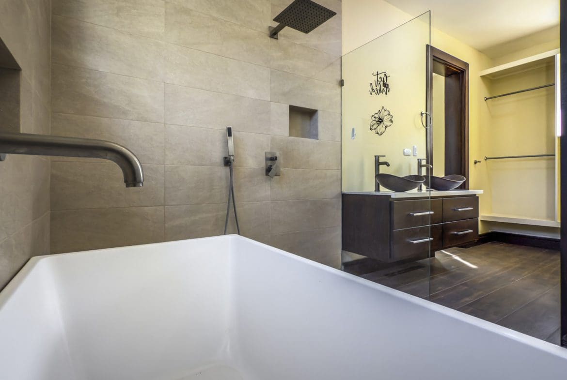 buyDRproperty Modern bathroom with tub, shower, double vanity, and walk-in closet in La Mulata villa. Sosua Real Estate