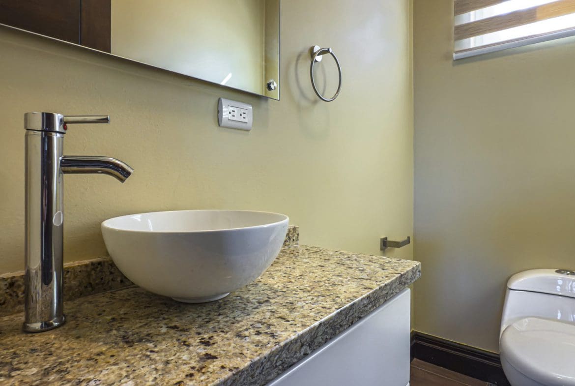 buyDRproperty Modern bathroom with vessel sink, granite countertop, and toilet. For sale villa in La Mulata. Sosua Real Estate