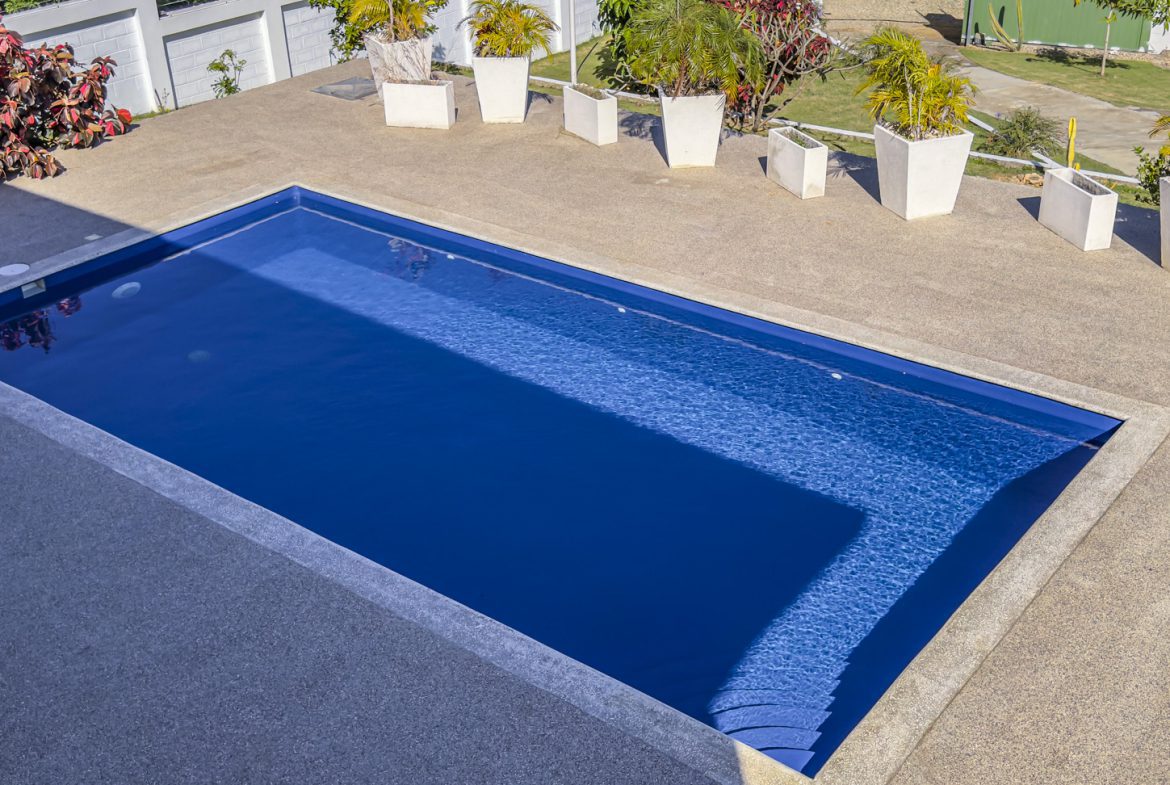 buyDRproperty Swimming pool at a 3 bedroom villa for sale in La Mulata, Dominican Republic. Outdoor view with potted plants. Sosua Real Estate