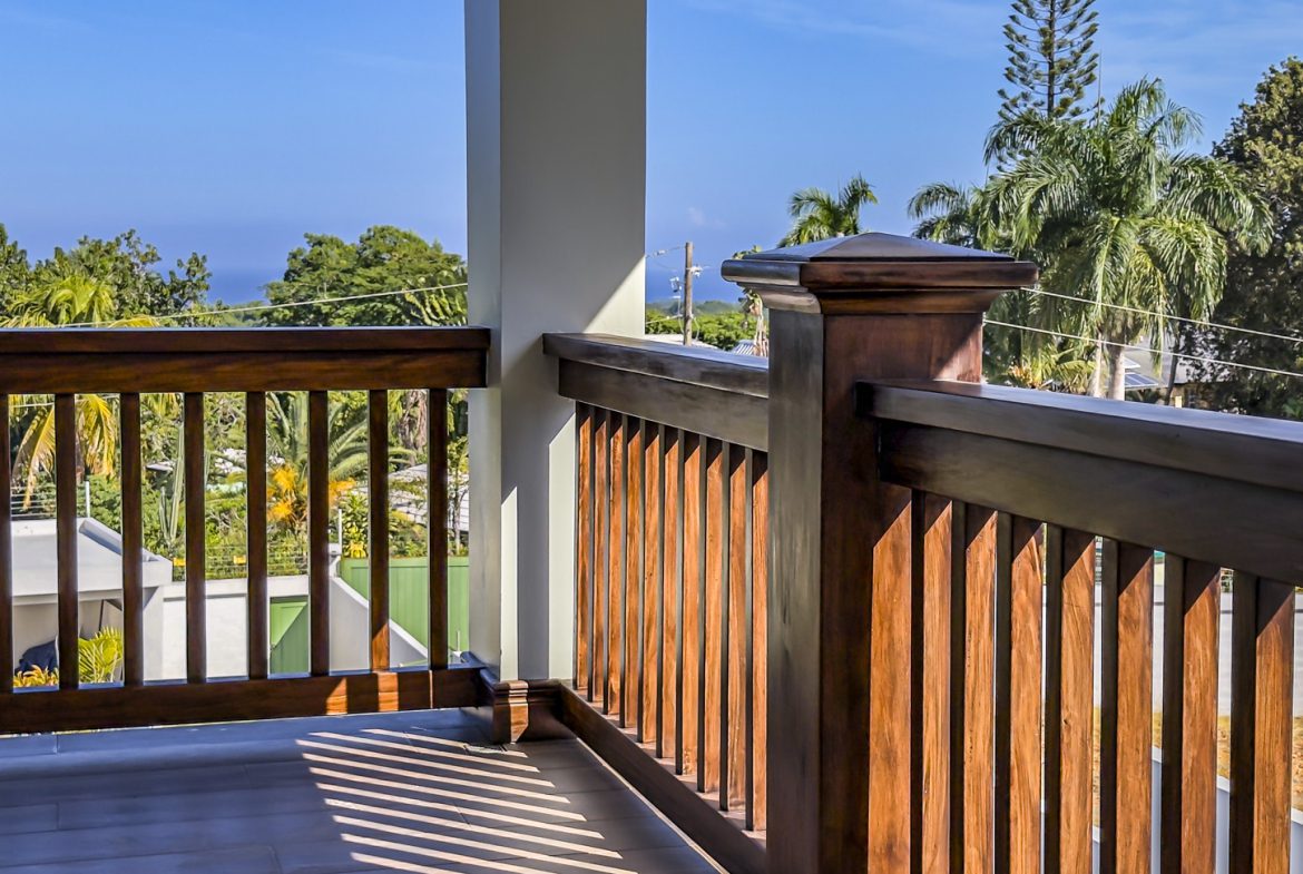 buyDRproperty Balcony with wooden railings in La Mulata villa, offering views of lush tropical landscape. Sosua Real Estate
