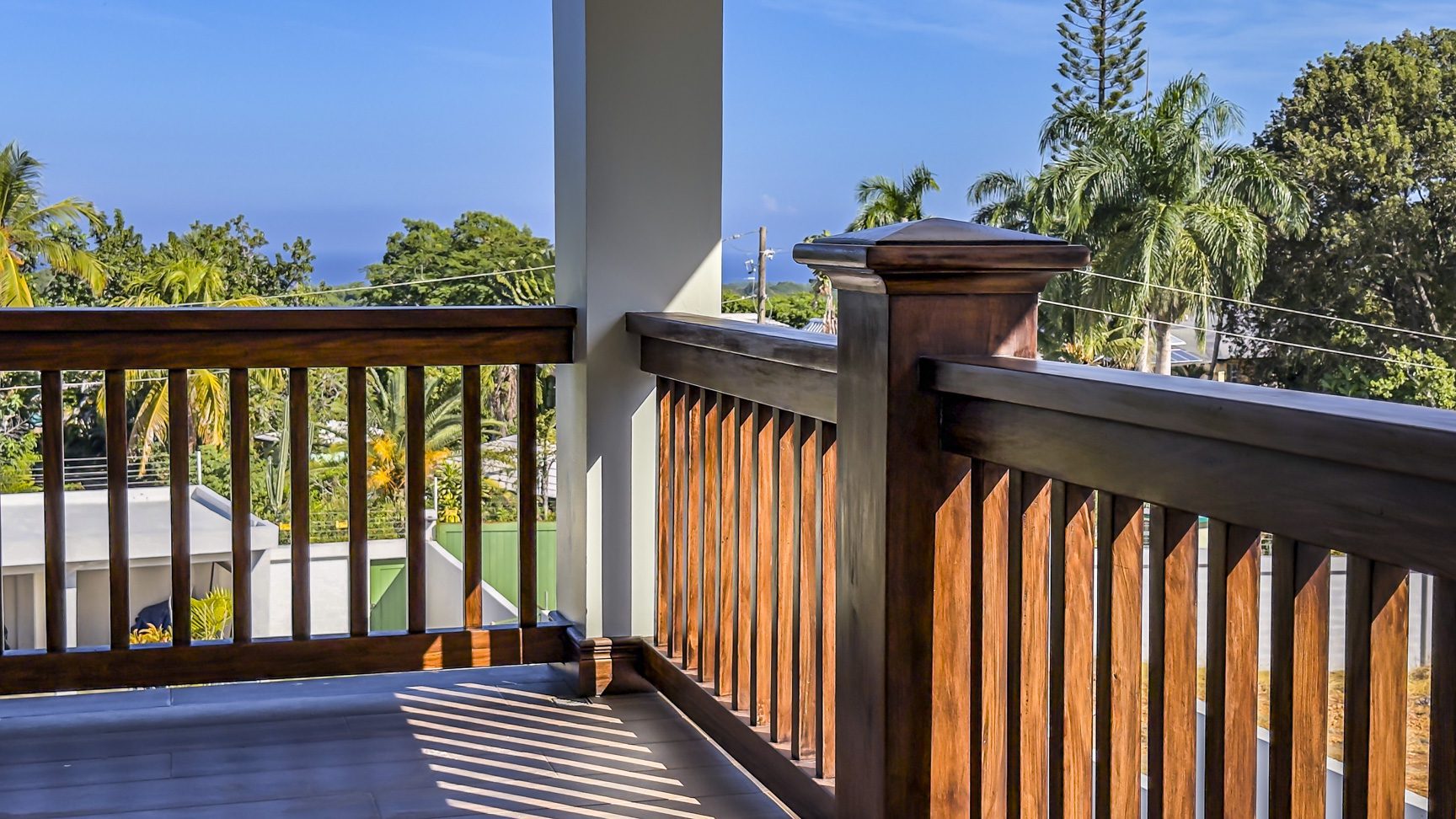 buyDRproperty Balcony with wooden railings in La Mulata villa, offering views of lush tropical landscape. Sosua Real Estate