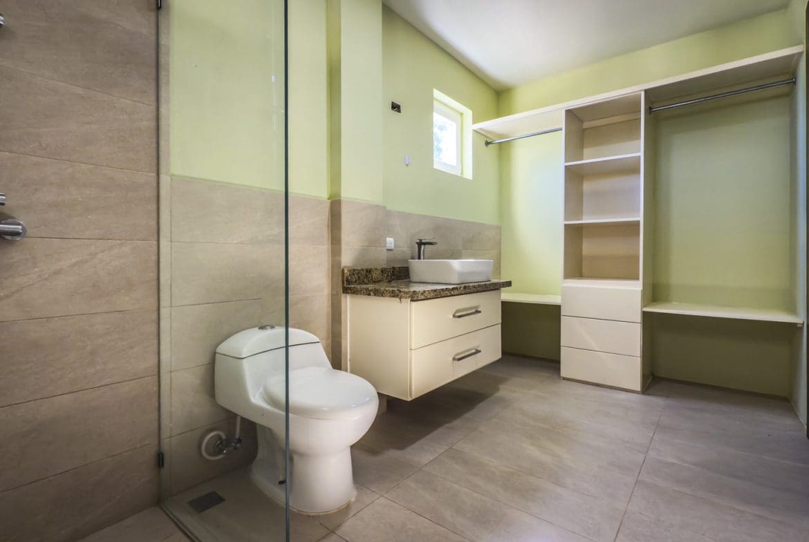 buyDRproperty Bathroom with toilet, shower, vanity, and open wardrobe in La Mulata villa. Sosua Real Estate