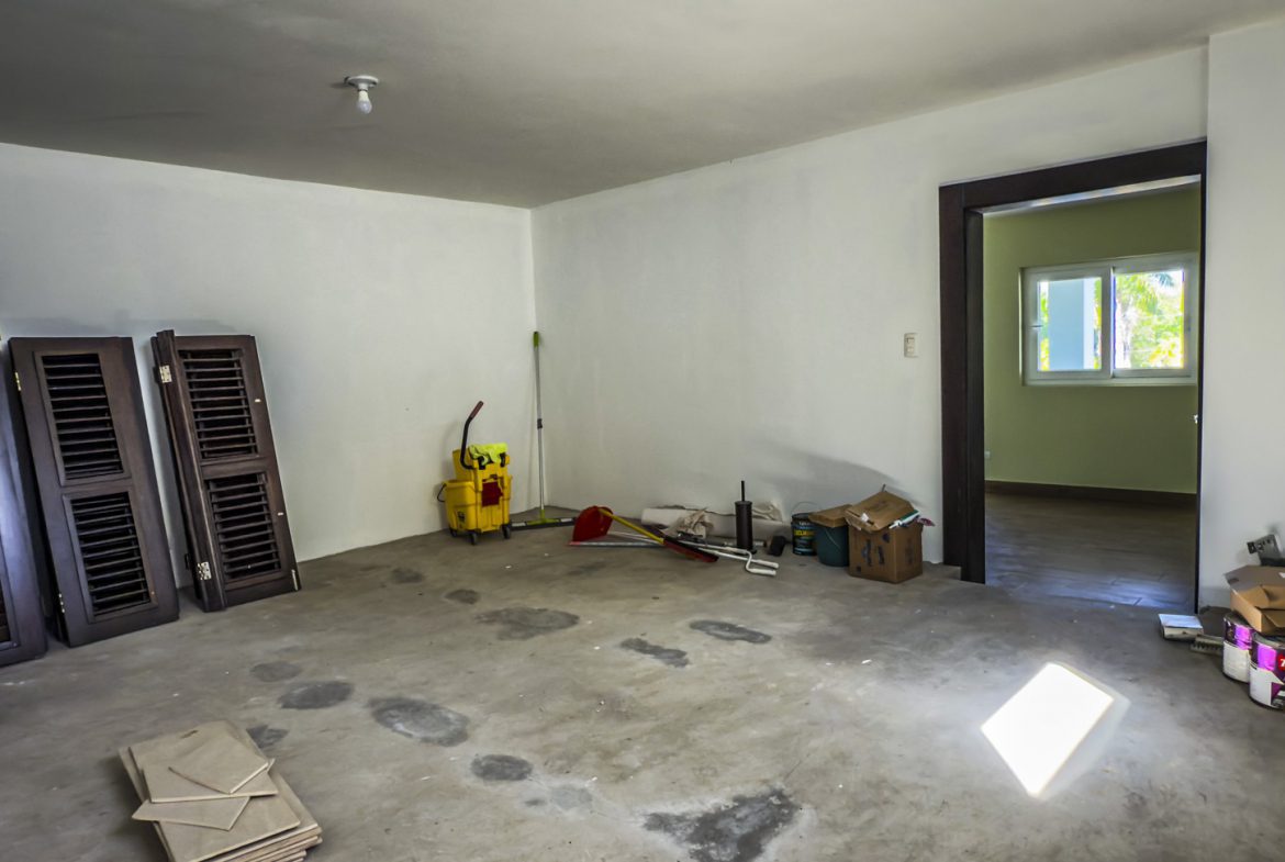 buyDRproperty Unfinished room in La Mulata villa for sale, showing concrete floor, shutters, and doorway. Sosua Real Estate