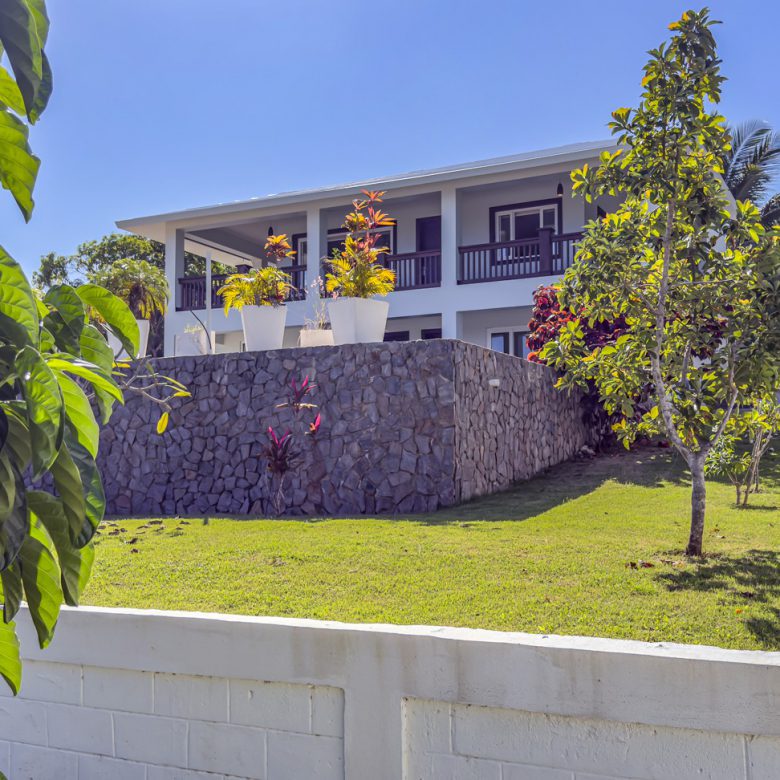 Buydrproperty La Mulata Villa for Sale Three bedroom House with Stone Foundation Balcony and Manicured Lawn on a Sunny Day Sosua Real Estate Buydrpropertycom Buydrpropertycom