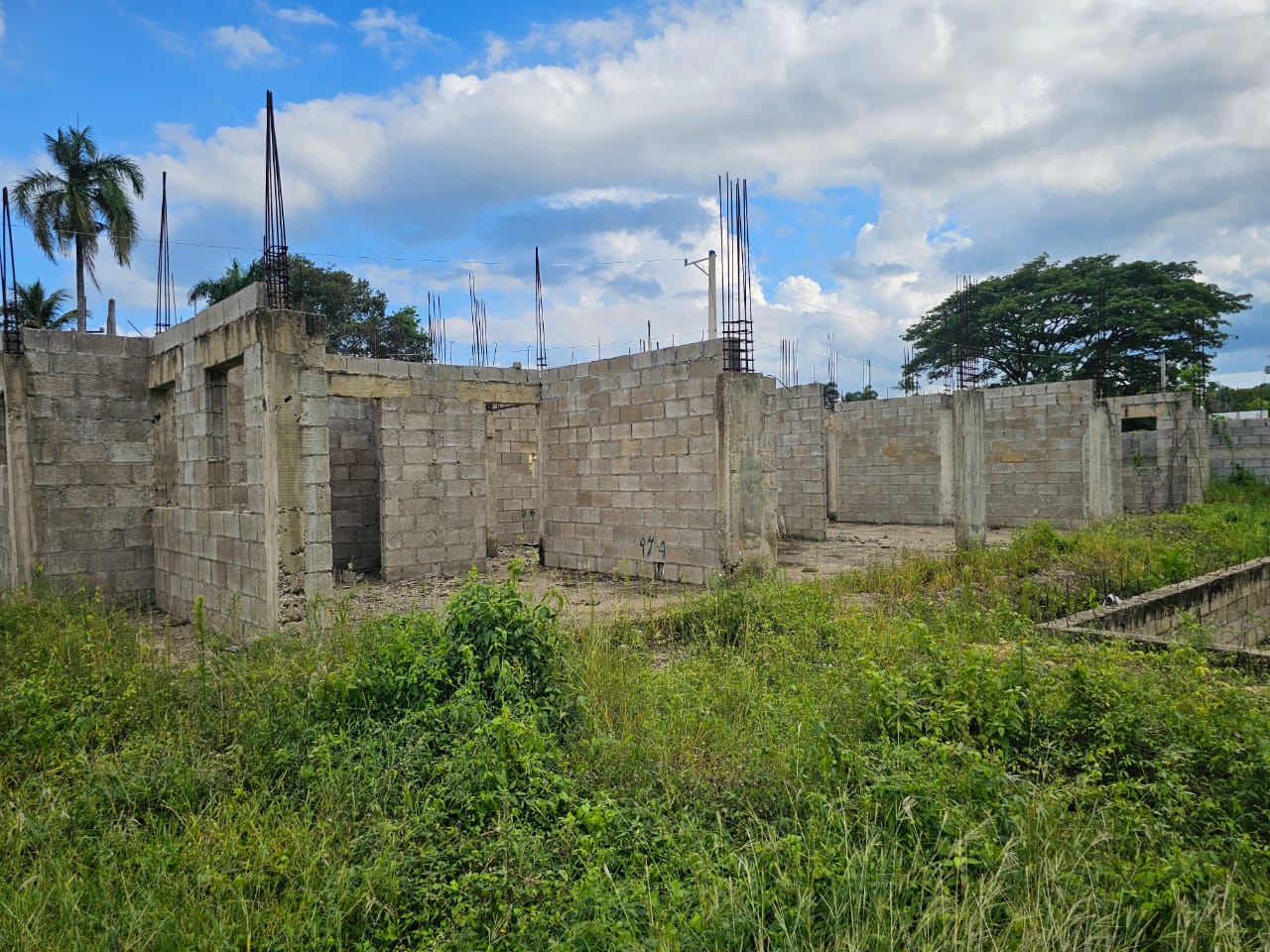 buyDRproperty Construction started on a lot near Sosúa, showing concrete block walls and rebar for a potential casa linda development. Sosua Real Estate