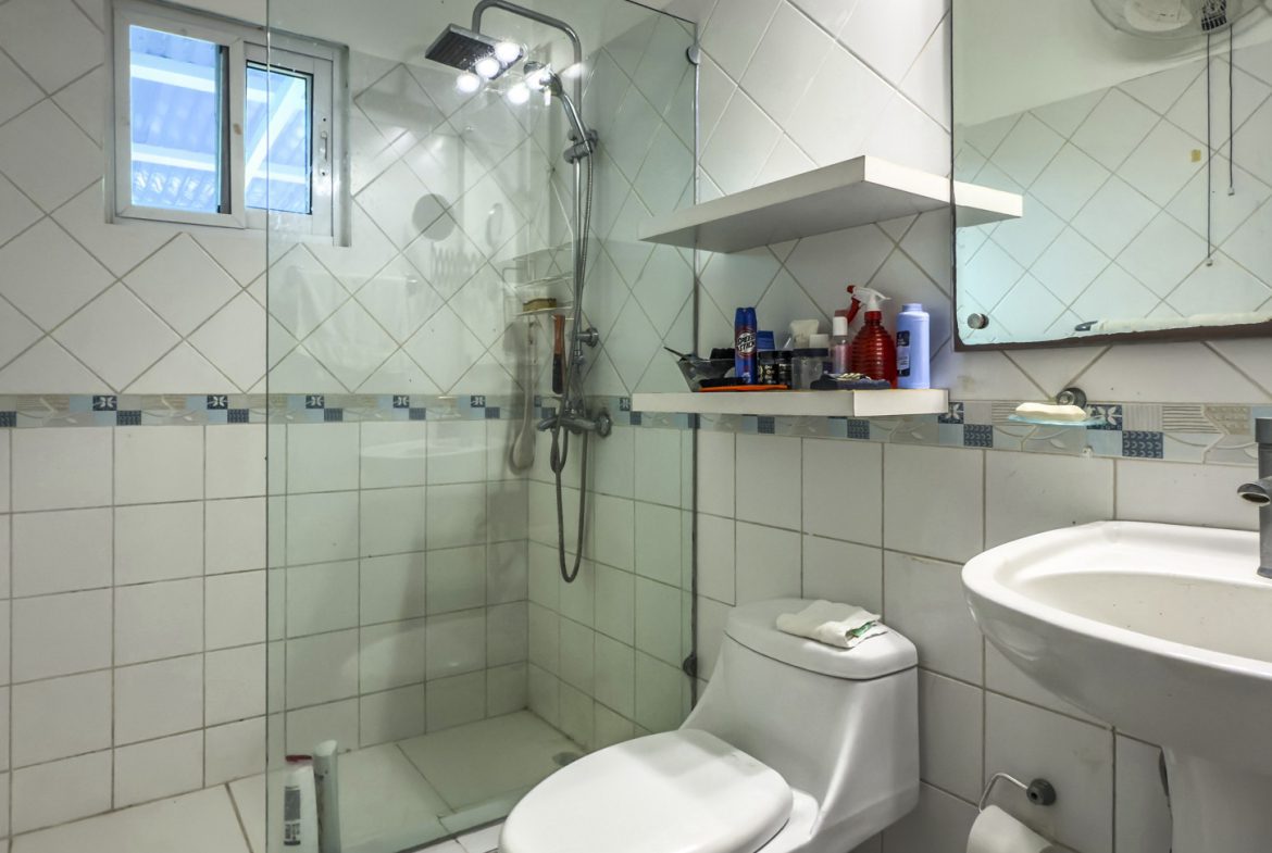 buyDRproperty Bathroom in Colibri villa with white tile, shower, toilet, and sink. Sosua Real Estate