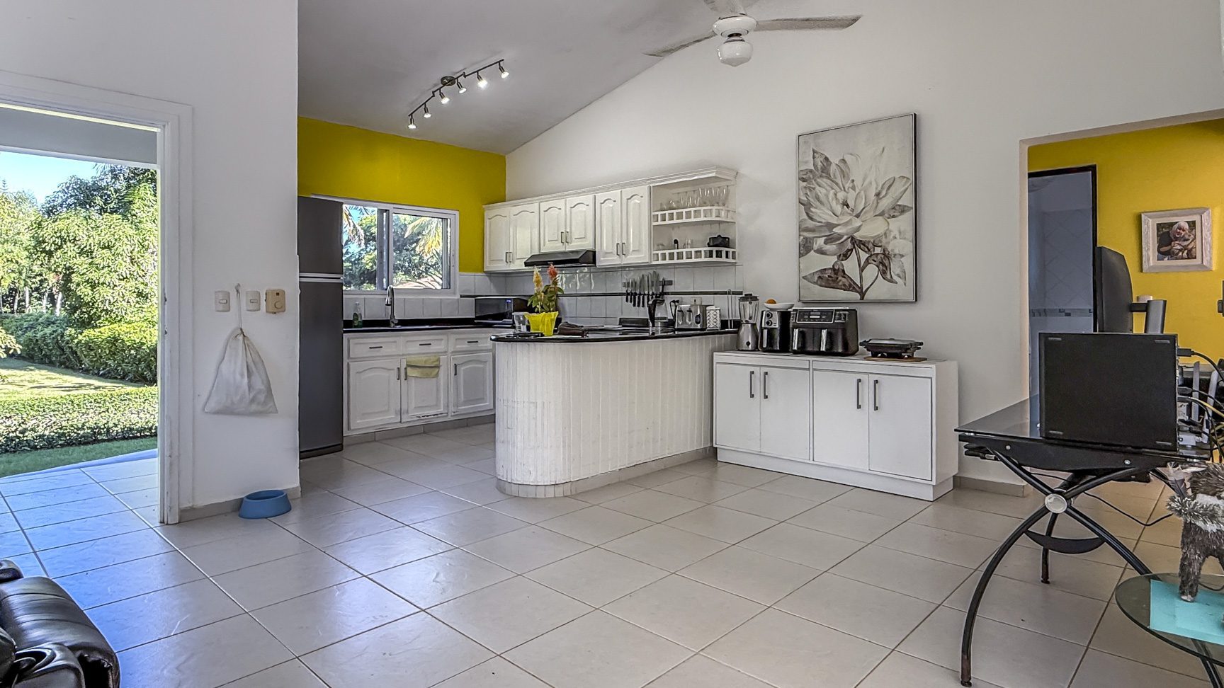 buyDRproperty Bright kitchen in Colibri villa with white cabinets and tile floor, part of a tropical oasis. Sosua Real Estate