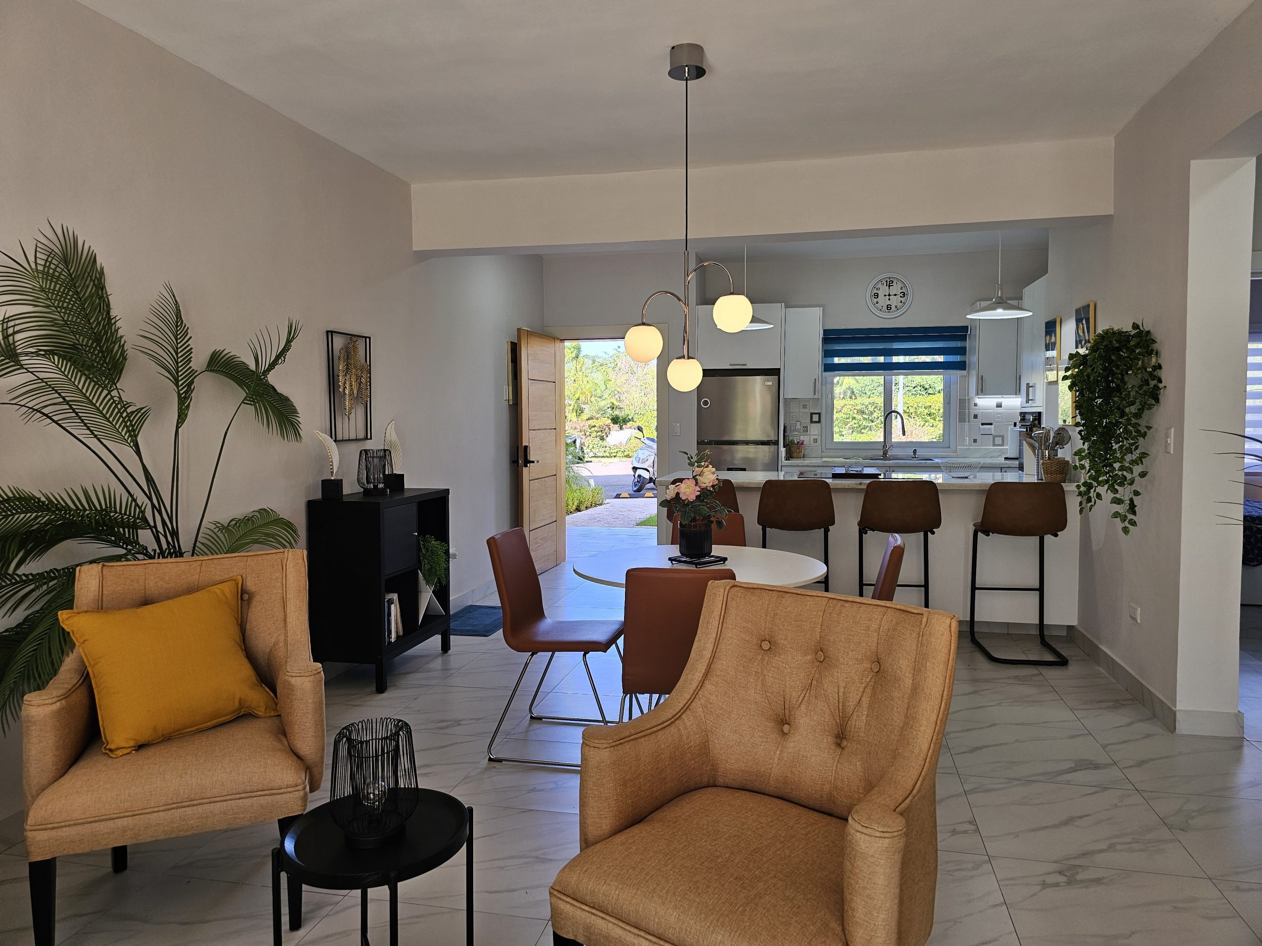 buyDRproperty Open-plan living: kitchen, dining, and seating area with neutral tones and modern decor. Sosua Real Estate