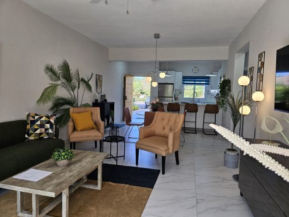 buyDRproperty Open-concept living room with modern furniture and bright, natural light. Sosua Real Estate