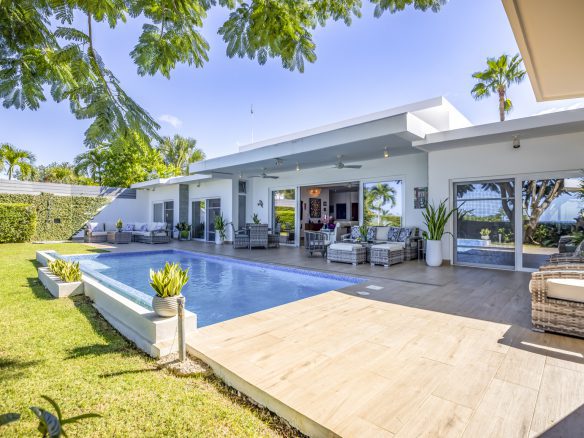 buyDRproperty Luxury villa with pool, patio, and lush green lawn. Sosua Real Estate
