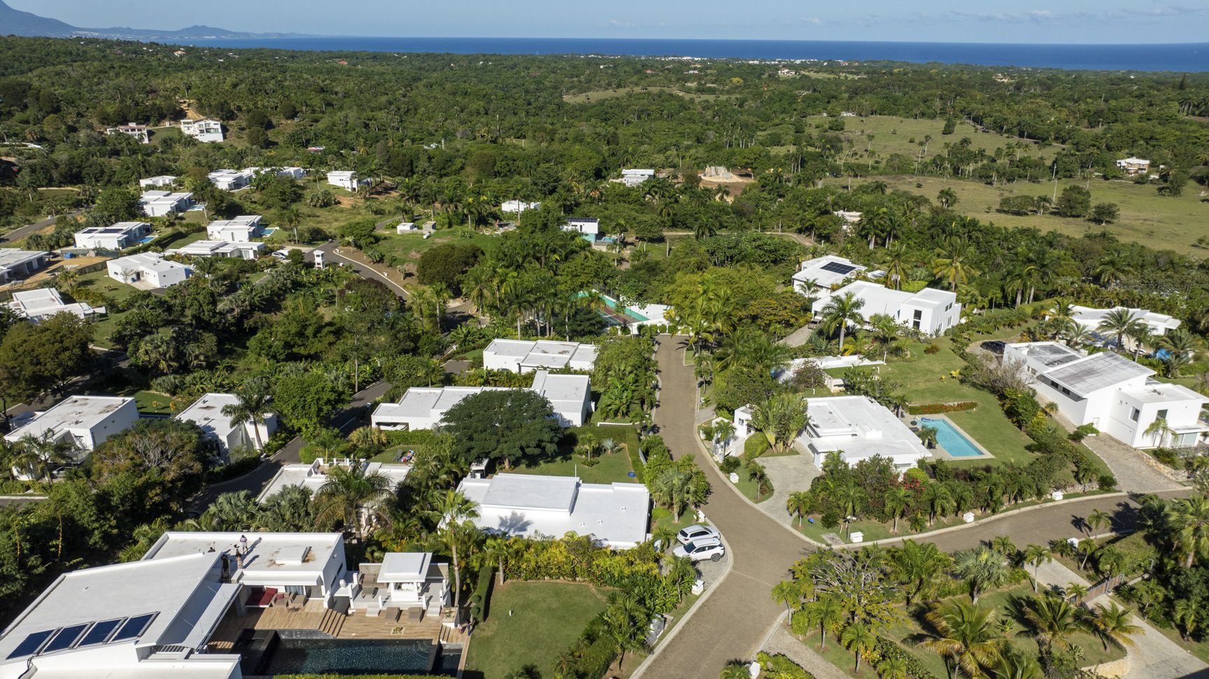 buyDRproperty Aerial view of luxury villas with pools in a tropical setting. Sosua Real Estate