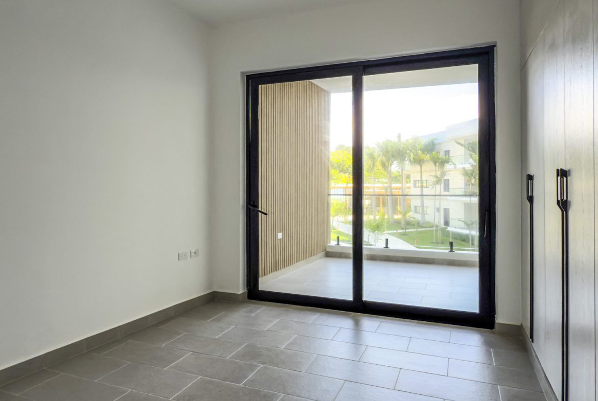 buyDRproperty Bright, modern room with sliding glass doors to a balcony and built-in wardrobe. Sosua Real Estate