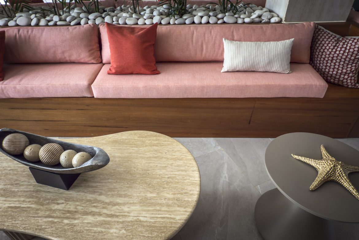 buyDRproperty Pink sofa with decorative pillows, decorative bowls, and a starfish on tables. Sosua Real Estate