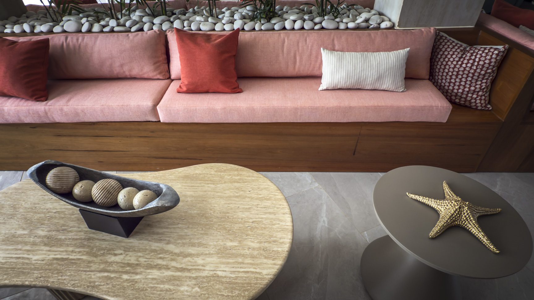 buyDRproperty Pink sofa with decorative pillows, decorative bowls, and a starfish on tables. Sosua Real Estate