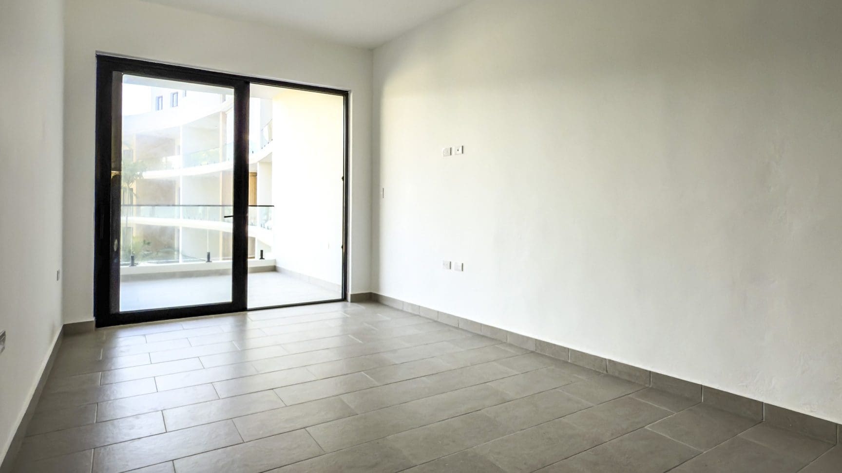 buyDRproperty Spacious empty room with tiled floor and large sliding glass door Sosua Real Estate