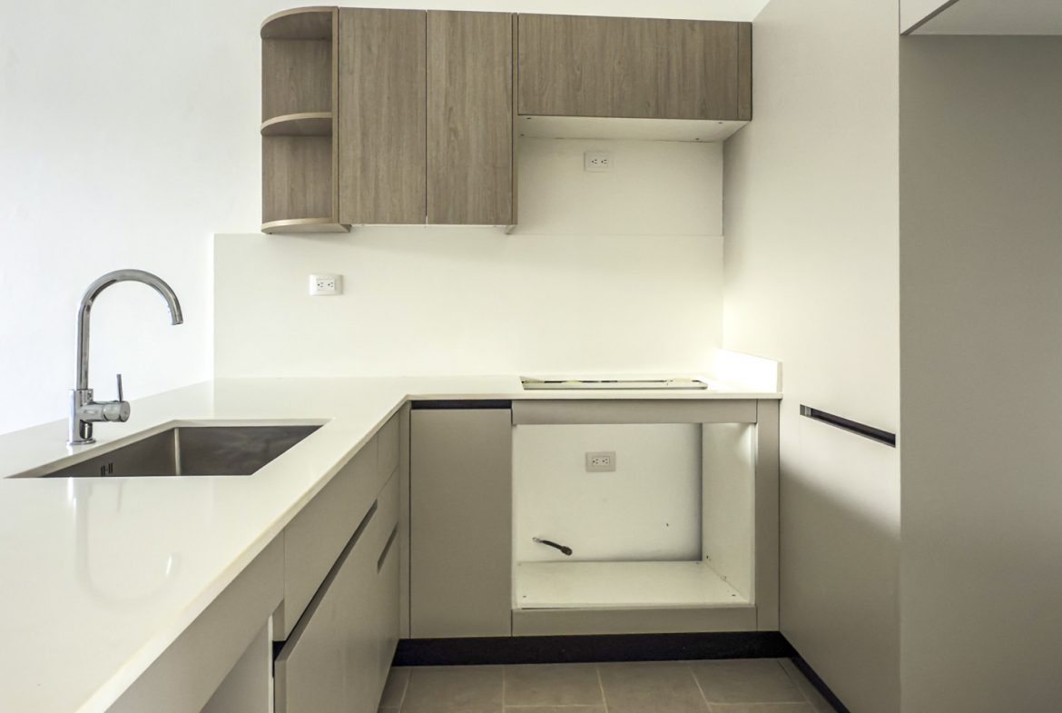 buyDRproperty Modern kitchen with stainless steel sink, light wood cabinets, and white countertops. Sosua Real Estate