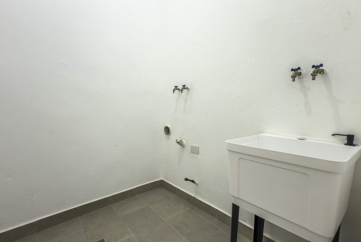 buyDRproperty Laundry room with a utility sink, faucet fixtures, and gray tile floor. Sosua Real Estate