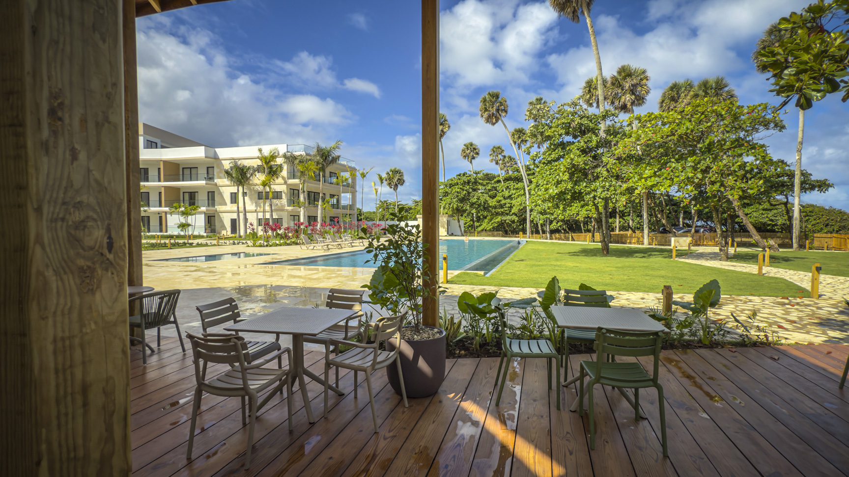 buyDRproperty Outdoor dining area overlooking a pool and tropical landscape at a resort. Sosua Real Estate