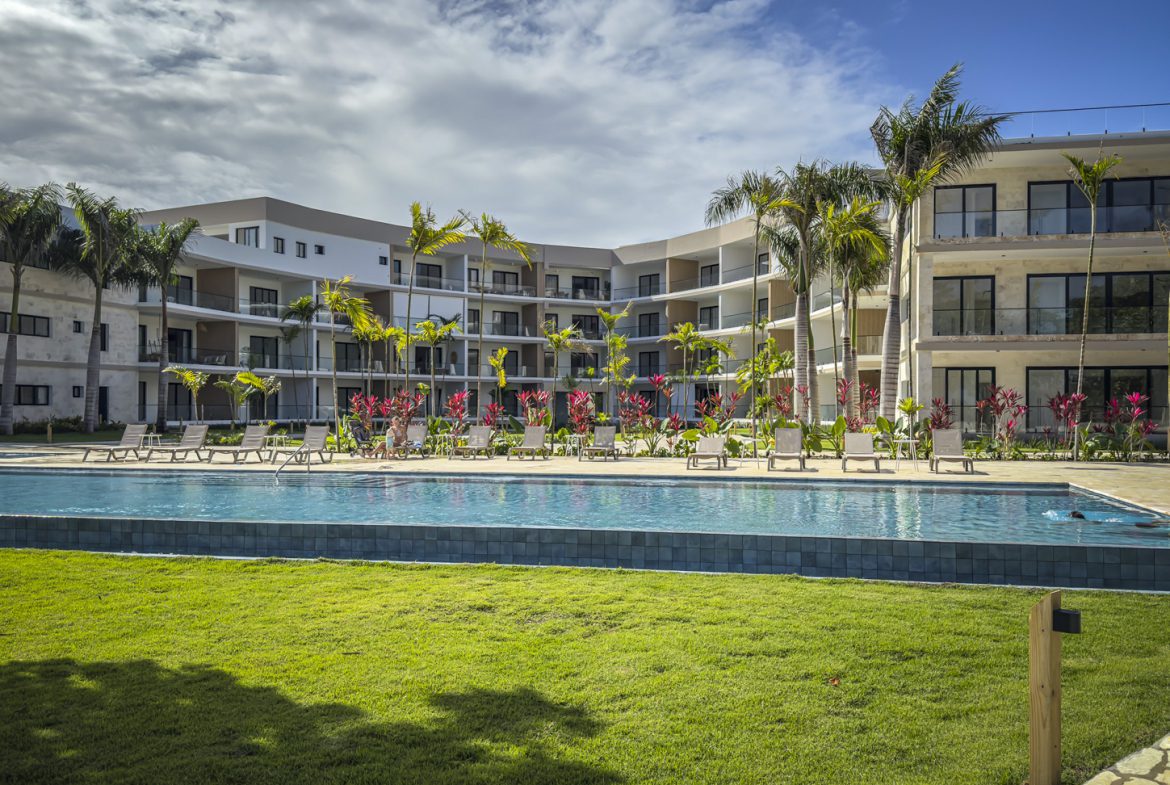 buyDRproperty Luxury beach resort with pool, palm trees, and modern architecture. Sosua Real Estate