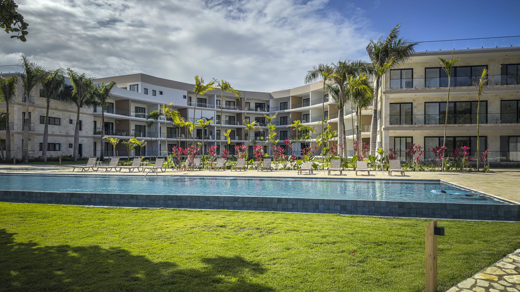 buyDRproperty Luxury beach resort with pool, palm trees, and modern architecture. Sosua Real Estate