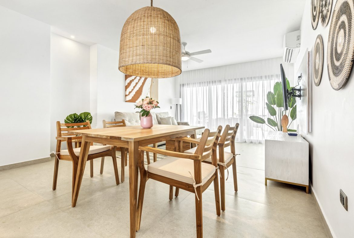buyDRproperty Light wood dining set under a woven pendant in a modern living space. Sosua Real Estate