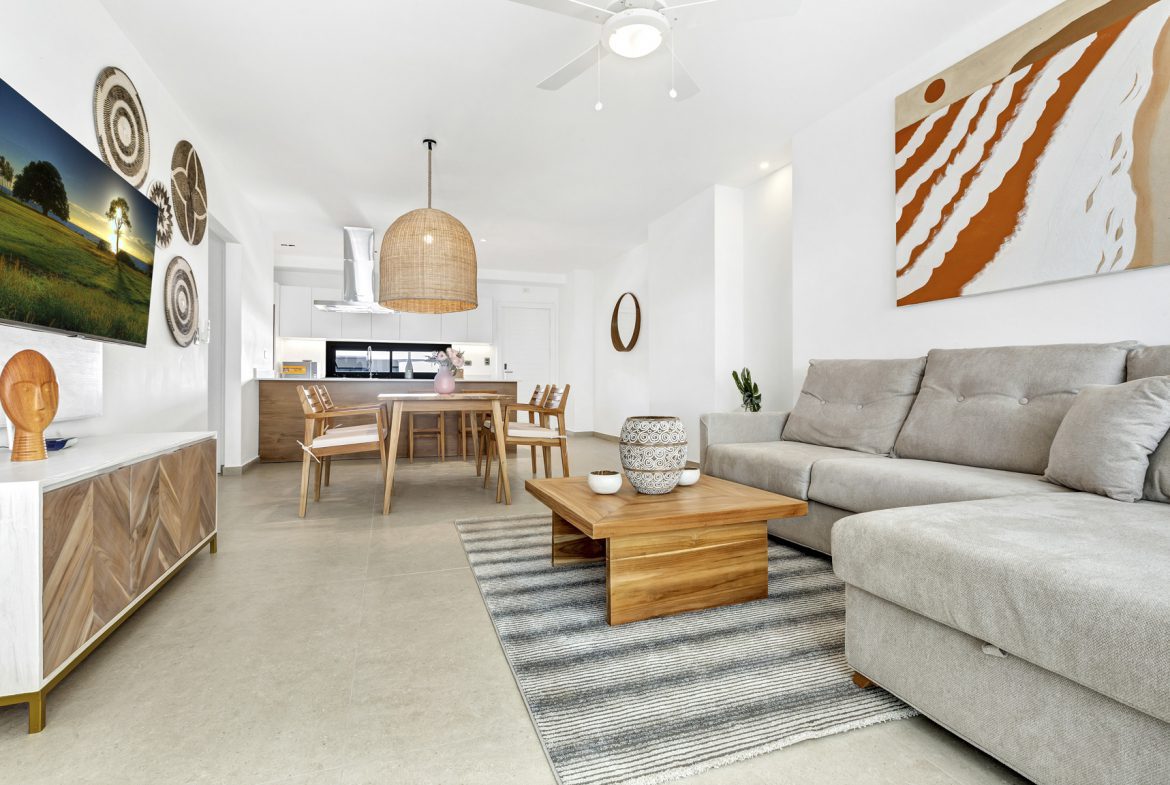 buyDRproperty Bright, open-plan living room with a sectional sofa, dining area, and a TV. Sosua Real Estate