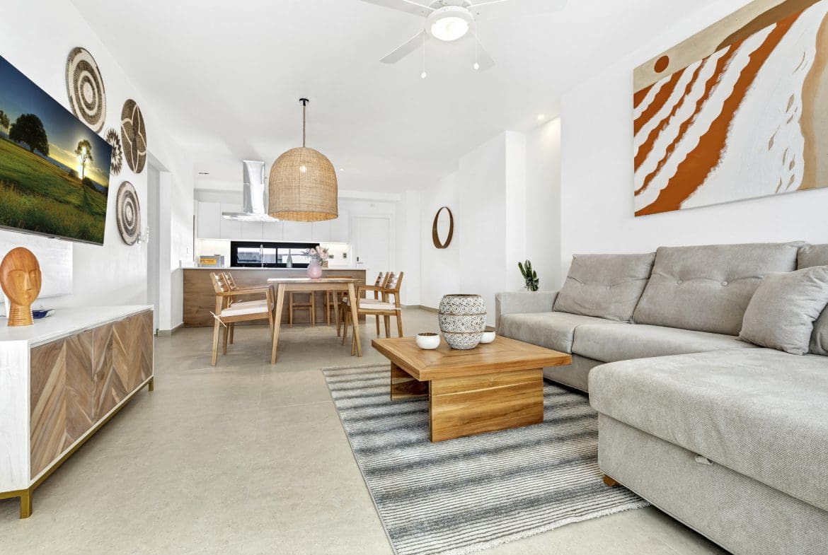 buyDRproperty Bright, open-plan living room with a sectional sofa, dining area, and a TV. Sosua Real Estate