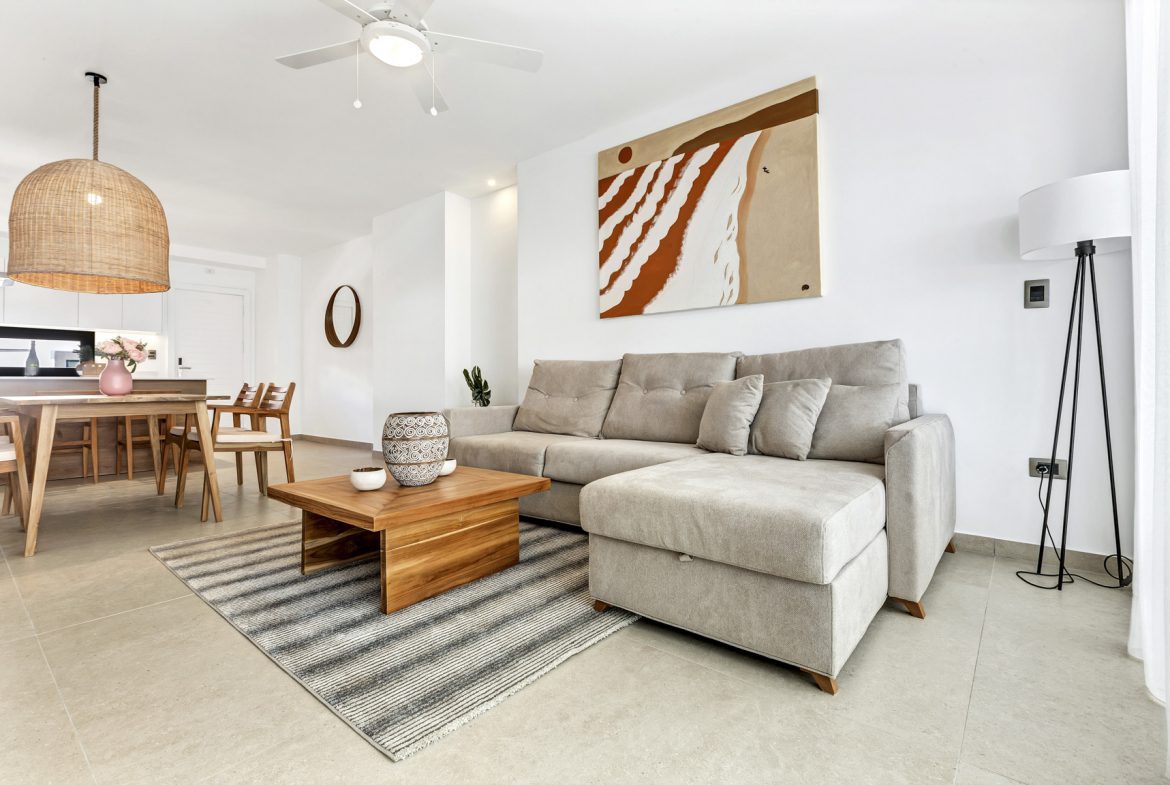 buyDRproperty Bright living room with beige sofa, wooden coffee table, dining area, and modern art. Sosua Real Estate