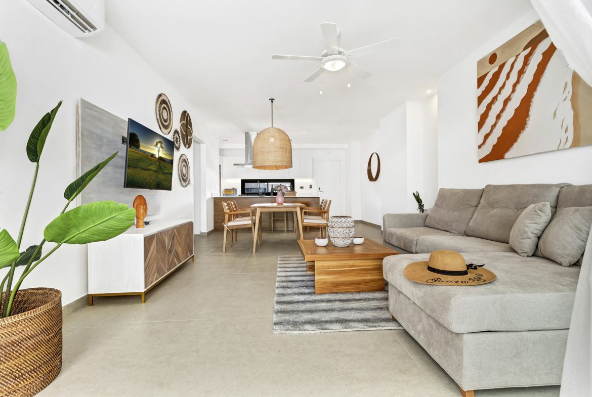 buyDRproperty Modern living room with gray couch, wooden coffee table, and potted plant Sosua Real Estate