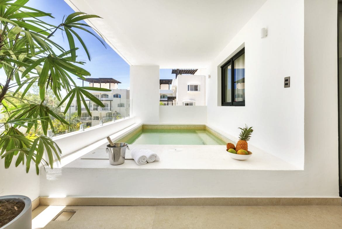 buyDRproperty Luxury resort balcony with plunge pool, fresh fruit, and chilled champagne. Tropical vacation vibes. Sosua Real Estate