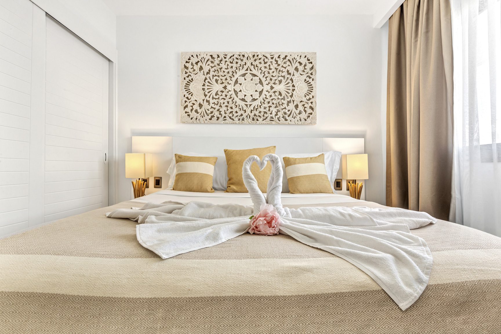 buyDRproperty Hotel room bed with swan towel art and decorative wall panel. Sosua Real Estate
