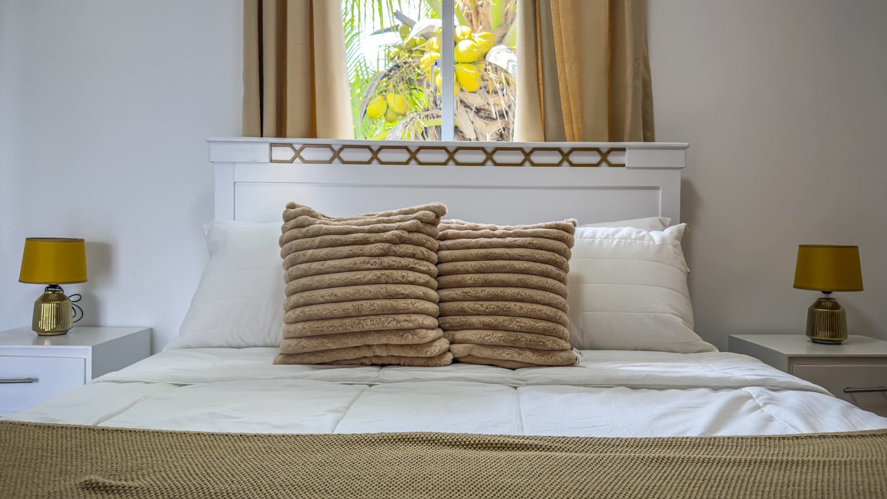 buyDRproperty Bedroom with white bed, textured pillows, and tropical view. Sosua Real Estate