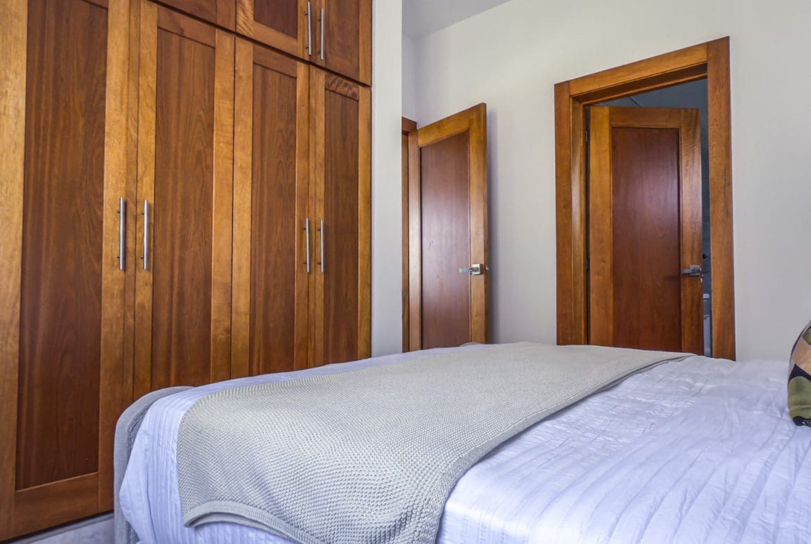 buyDRproperty Bedroom with modern closet, bed, and storage. Closet design for bedroom storage. Sosua Real Estate