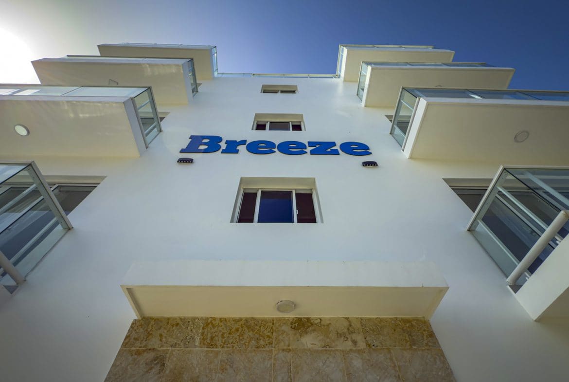 buyDRproperty Breeze hotel exterior with modern balconies against a blue sky. Sosua Real Estate