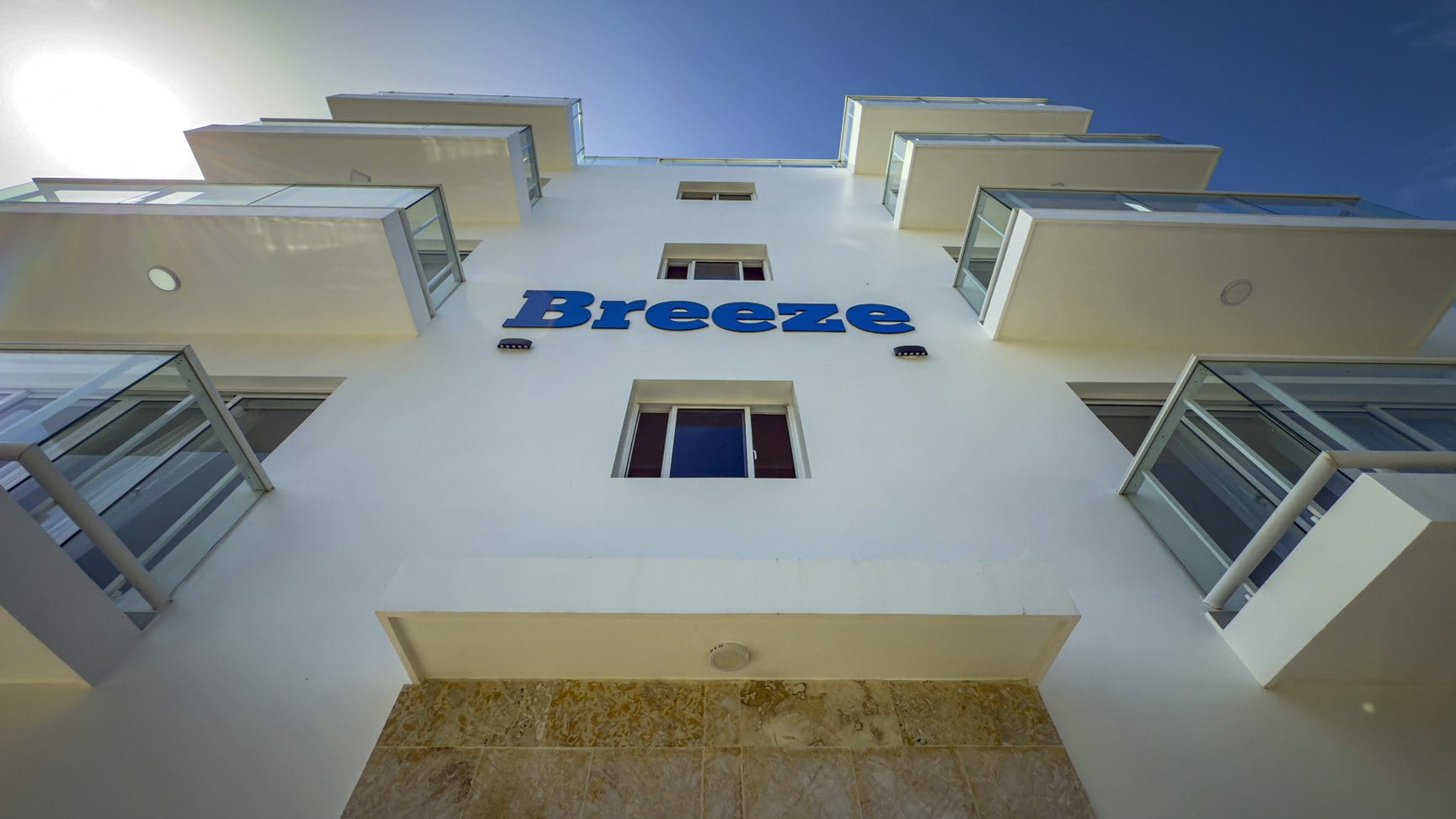 buyDRproperty Breeze hotel exterior with modern balconies against a blue sky. Sosua Real Estate