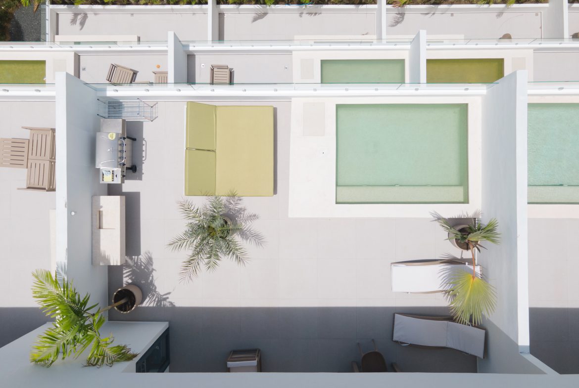 buyDRproperty Aerial view of a modern rooftop terrace with pool, lounge area, and lush greenery. Sosua Real Estate