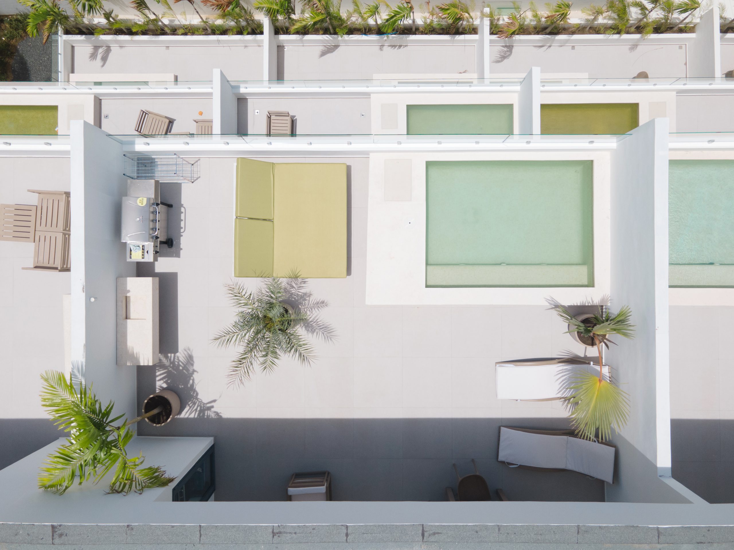 buyDRproperty Aerial view of a modern rooftop terrace with pool, lounge area, and lush greenery. Sosua Real Estate