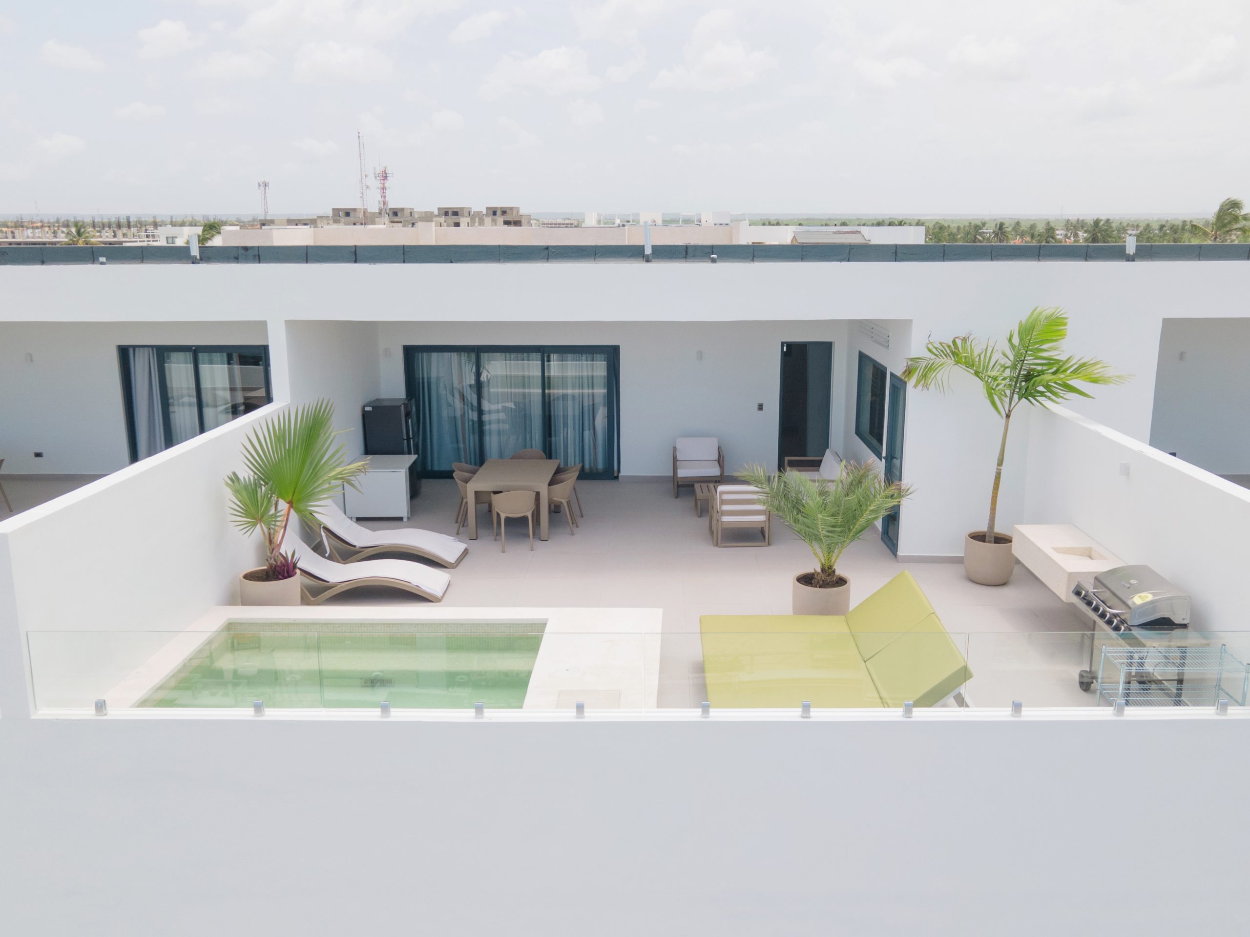 buyDRproperty Rooftop terrace with pool, lounge chairs, dining set, and grill. Sosua Real Estate
