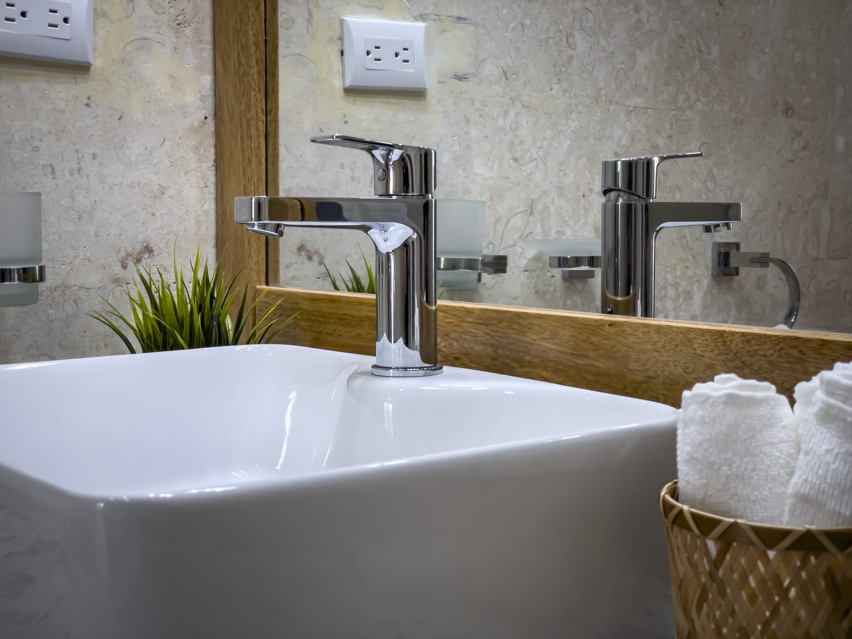 buyDRproperty Modern bathroom sink with chrome faucet, white square basin, and rolled towels. Sosua Real Estate