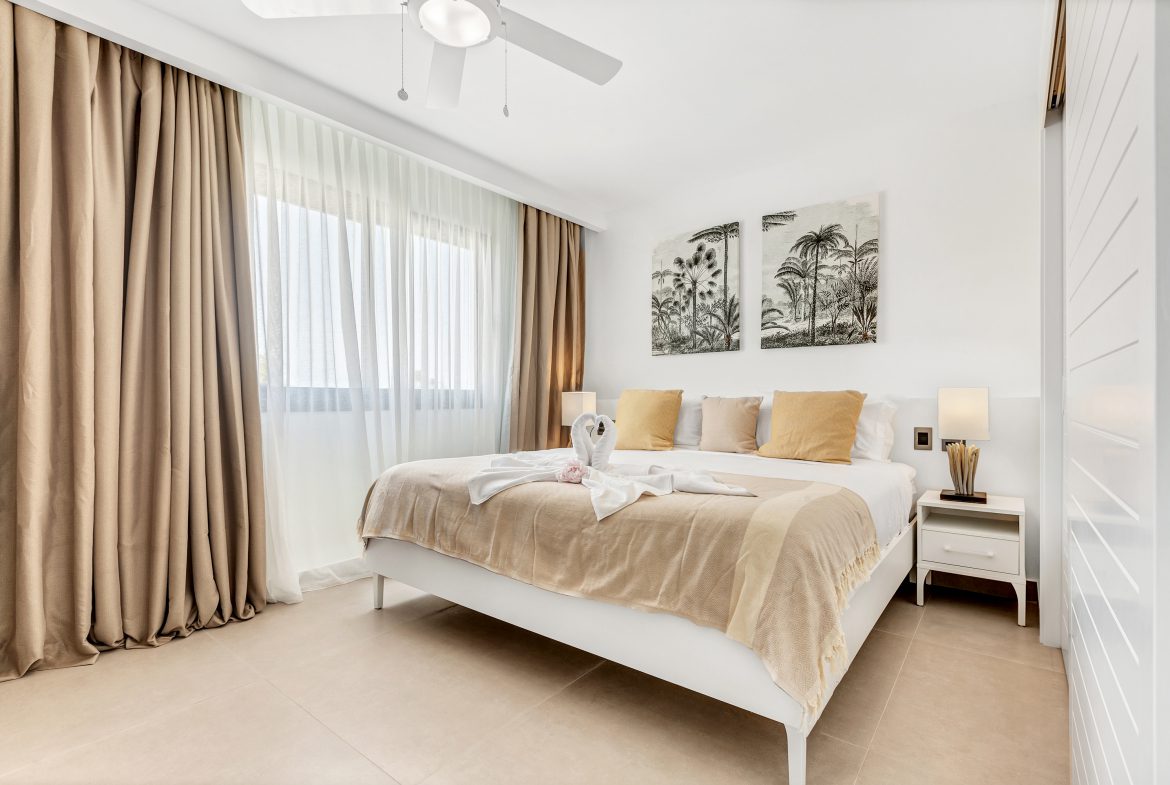 buyDRproperty Light and airy coastal bedroom with tropical decor and white bed. Sosua Real Estate