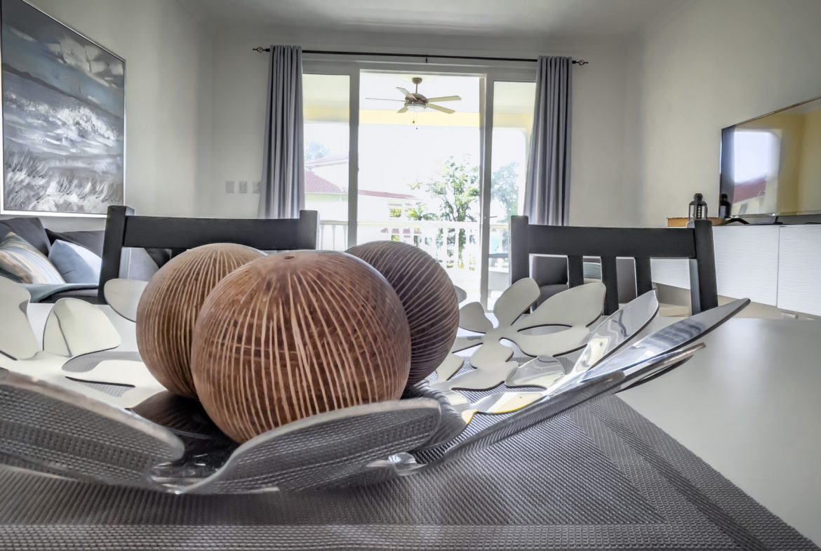 buyDRproperty Elegant dining room decor: Decorative bowl with brown spheres on a gray placemat. Sosua Real Estate