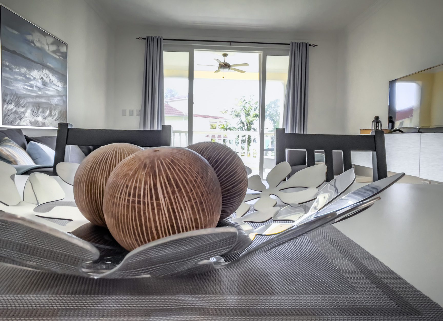 buyDRproperty Elegant dining room decor: Decorative bowl with brown spheres on a gray placemat. Sosua Real Estate