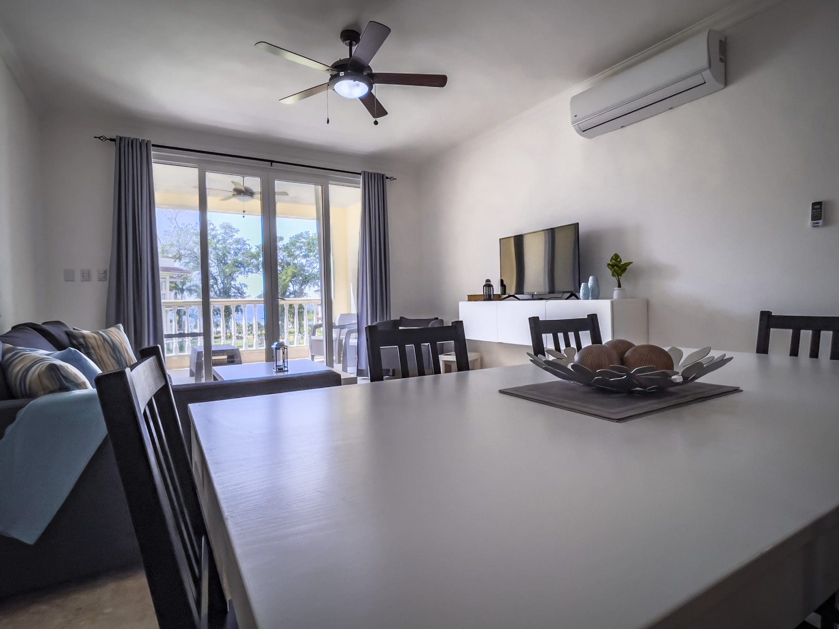 buyDRproperty Bright living and dining area with patio doors leading to a balcony. Modern interior design. Sosua Real Estate