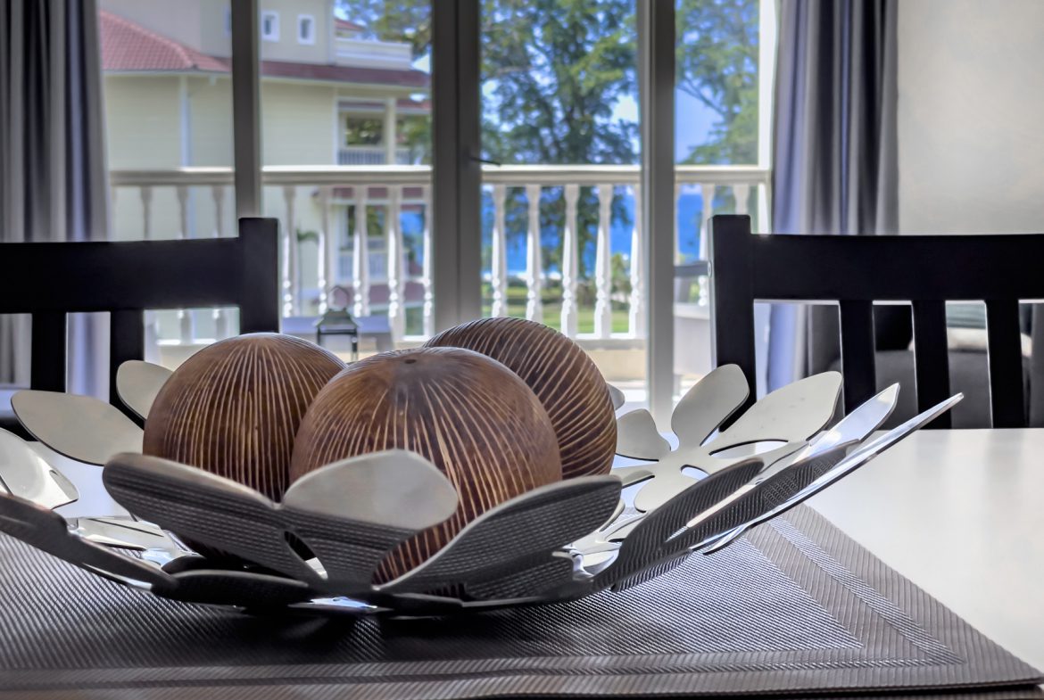 buyDRproperty Decorative bowl with wooden spheres on a dining table near a window. Sosua Real Estate